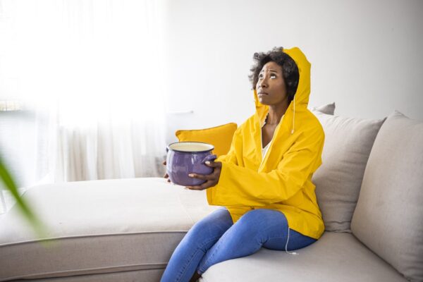 A Man In Yellow Gloves Performing Plumbing Maintenance Outdoors.
