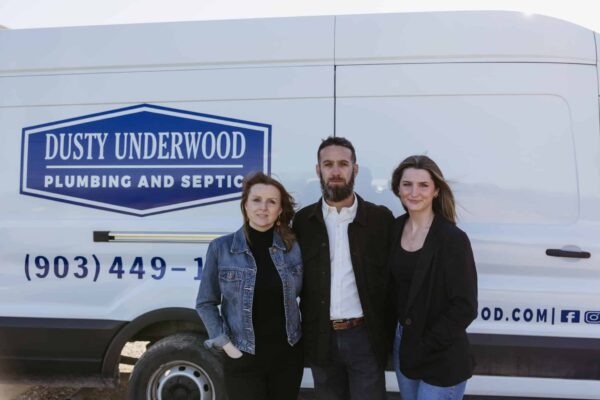 Three Members Of The Dusty Underwood Team Standing In Front Of A Van With Our Logo Printed On It.