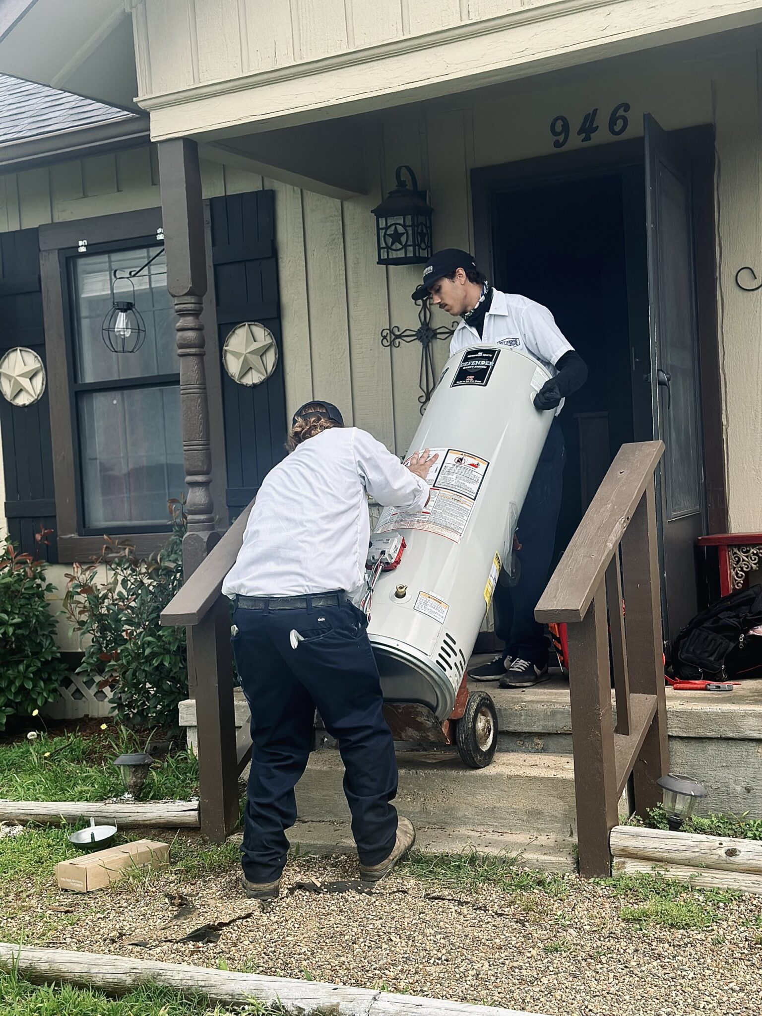 Two of Underwood’s trusted plumbers carrying a new water heater into a home.