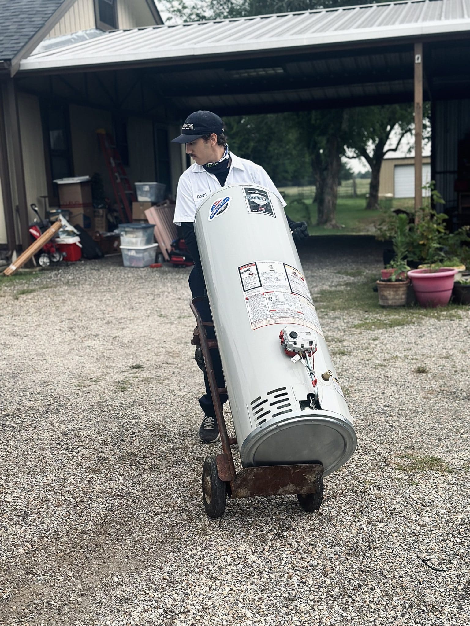 A plumber from Underwood Plumbing & Septic wheeling in a new water heater to a Texas home.