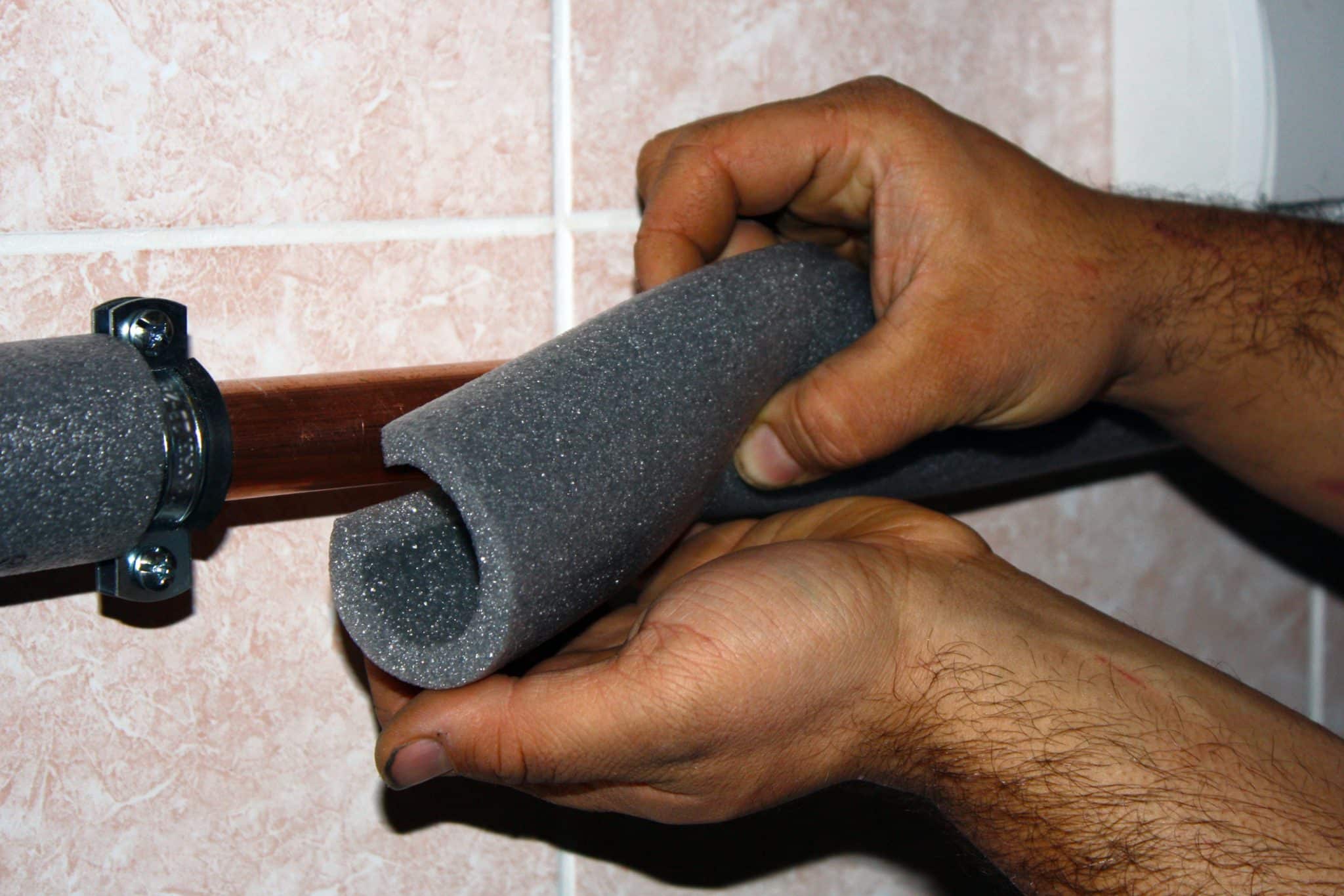A man uses foam to insulate his pipes and protect his plumbing during a freeze.